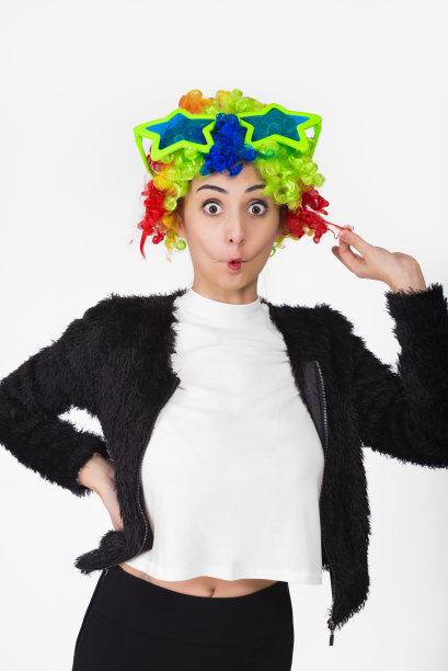 女孩戴着五颜六色的卷发，大眼镜和滑稽的面部表情。图片下载