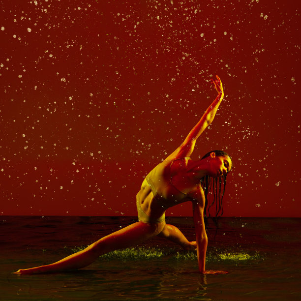 美丽和优雅。一个年轻美丽的芭蕾舞女演员在霓虹灯下的红色背景下跳舞。图片下载