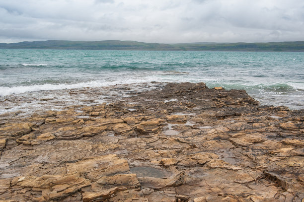 戏剧性的场景与海浪，岩石海岸和云图片下载
