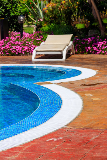 躺椅停在游泳池附近。水疗、休息、放松、度假、度假的概念图片下载