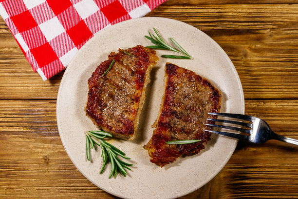 木桌上的迷迭香烤猪肉排。俯视图图片下载