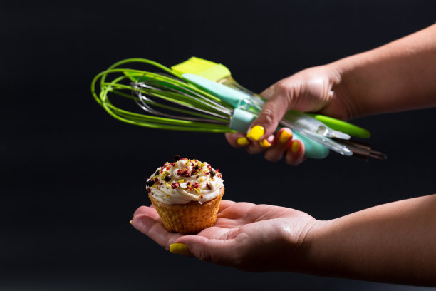 糕点师之手。杯形糕饼。在家做糖果。图片下载