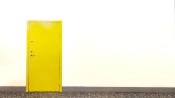 白色墙上黄色的门紧闭着图片下载