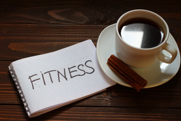 在一杯咖啡旁边的笔记本上写下健身的文字图片下载