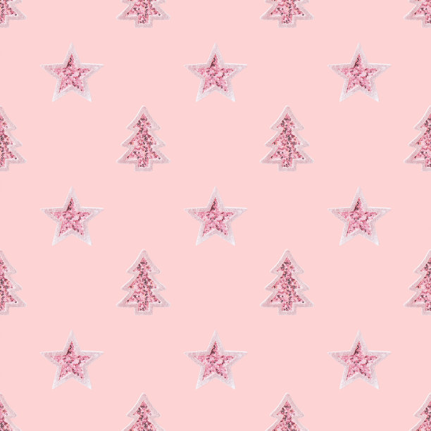 圣诞节图案与粉红色玩具圣诞树和闪闪发光的亮片的星星在粉红色的背景。图片下载