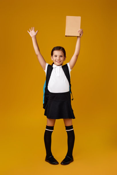 可爱的女学生与背包和书的全部长度。图片下载