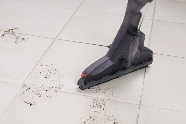 有脏点的浅色瓷砖，用清洗真空吸尘器清洗，特写，俯视图图片下载