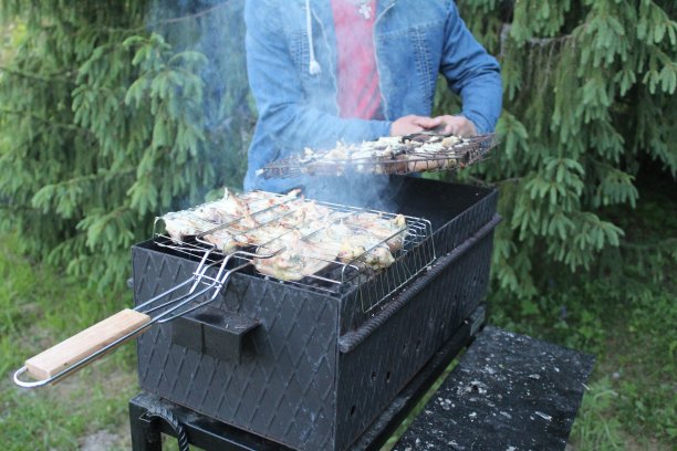 一个男人在烤架上烤鸡图片下载