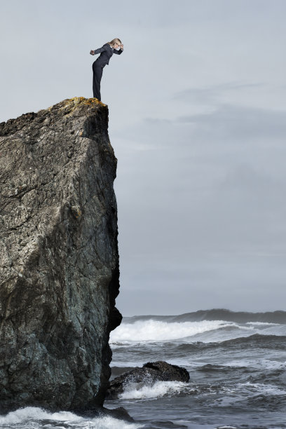 一个女人站在危险的悬崖边向下看冲浪图片下载