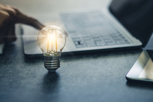 亮灯泡与笔记本电脑和书。商业与教育理念图片下载