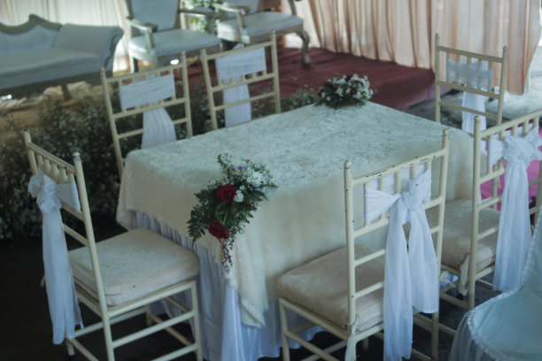 美丽的白色婚礼桌，在这里举行了婚礼(Akad nikah)，桌上和椅子上装饰着鲜花。图片下载