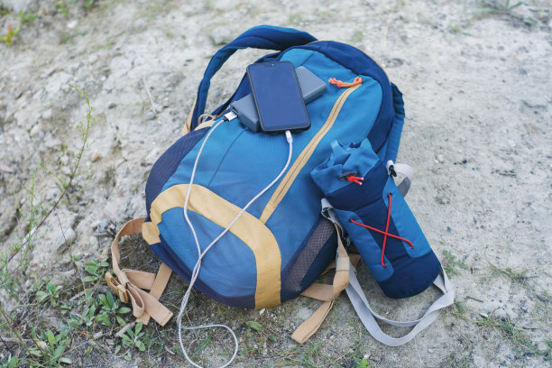 智能手机使用便携式充电器充电。充电宝在户外为手机充电，自带背包，适合在自然中旅游。图片下载