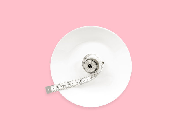 白色卷尺，白色圆形盘，粉红色背景。俯视图图片下载