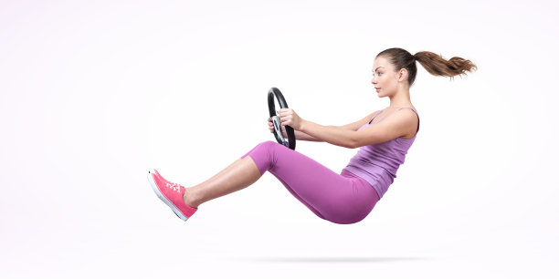 在灯光的背景下，一个穿着粉色背心的快乐小女孩手里握着一辆汽车的方向盘冲过马路。汽车的概念图片下载