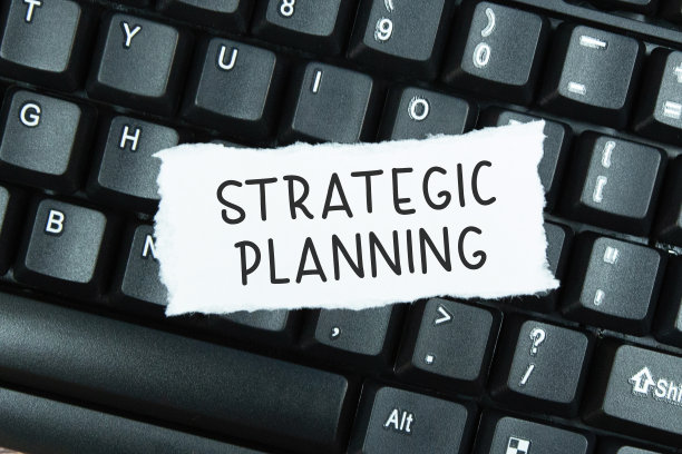 在笔记本电脑键盘上撕破的纸上写着“文本战略规划”图片下载