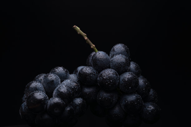 大的葡萄在黑色背景的照片。图片下载