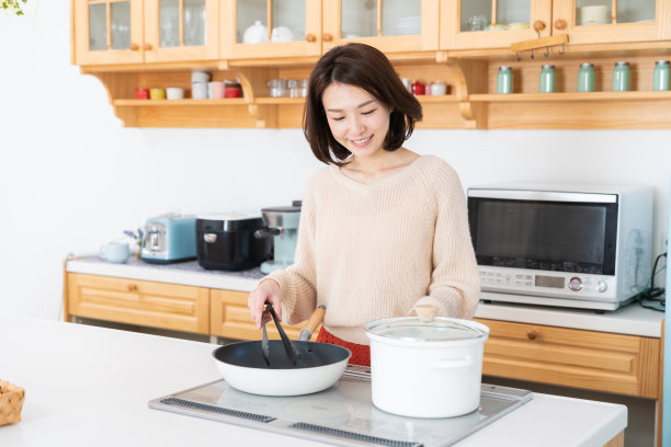 漂亮的亚洲女人在厨房做饭图片下载