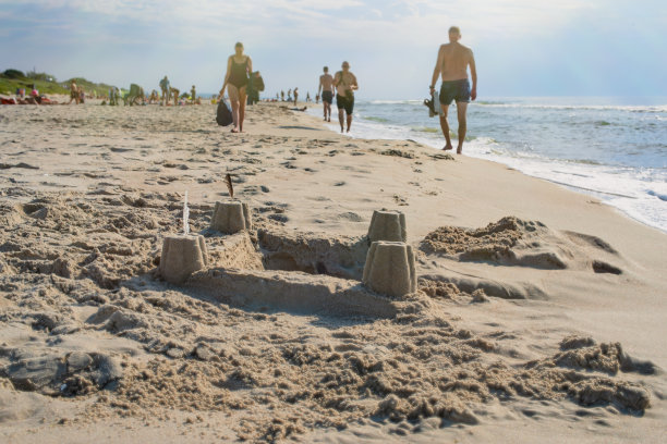 波罗的海海滩上的沙塔。背景中的人。图片下载