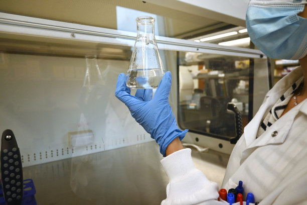 一个科学家在实验室里拿着烧瓶的特写镜头。图片下载