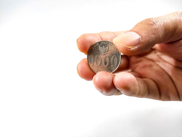 手拿白色背景的硬币图片下载