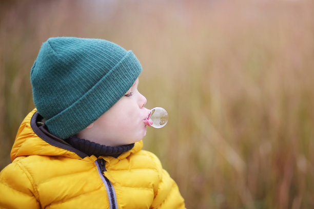 一个吹泡泡的小男孩的肖像图片下载