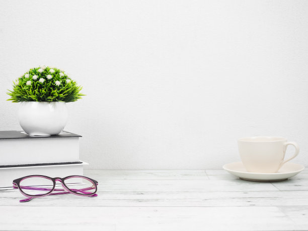 书玻璃杯和花瓶在桌上白色背景，工作场所在家里图片下载