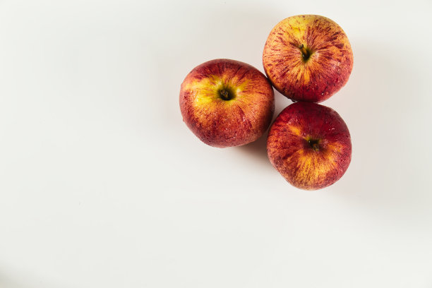 俯视图的三个红苹果与滴在白色的背景图片下载