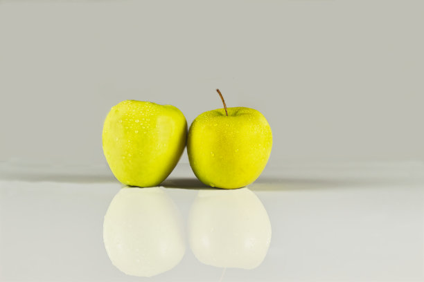 两个绿色的苹果，白色的背景上有水滴图片下载