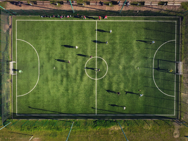 鸟瞰图绿色的足球场与未知的球员进行比赛图片下载