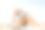 年轻女子坐在沙滩上用笔记本电脑工作。图片下载