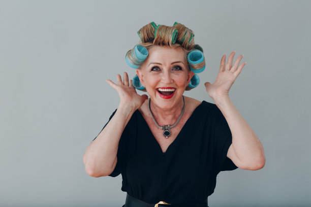 年老的老妇人，家庭主妇用卷发器把头发卷在头上图片下载