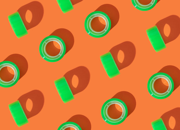 在亮橙色背景下用绿色校带做成的图案。透明胶带平铺鲜艳的背景设计。图片下载