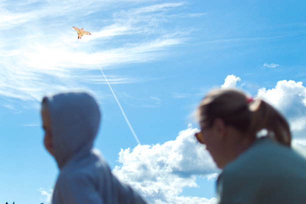 妈妈和儿子在河边玩风筝图片下载