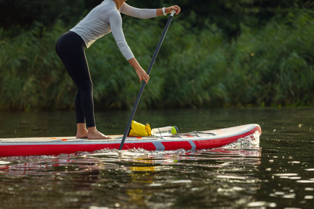 裁剪的形象，年轻的白人妇女，运动员，游客站在桨板上，SUP，练习独自。积极生活、运动、休闲的活动理念图片下载