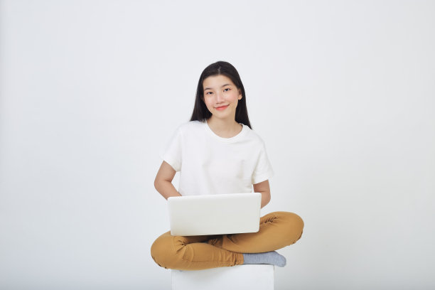 幸福女人的肖像随意坐在地板上，使用笔记本电脑隔离在白色背景图片下载