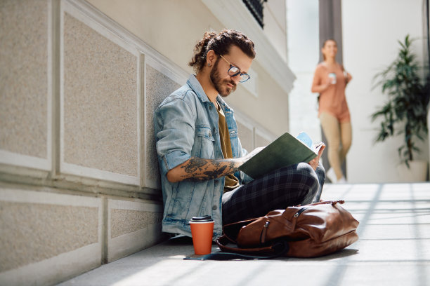 男大学生正在走廊里看书。图片下载