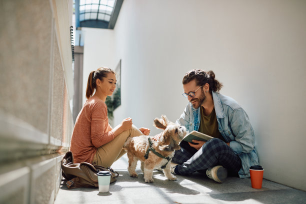 快乐的学生与他们的狗在大学走廊学习的乐趣。图片下载