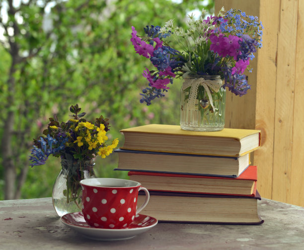 乡村门廊上的静物，一杯茶，一本书和春花。图片下载