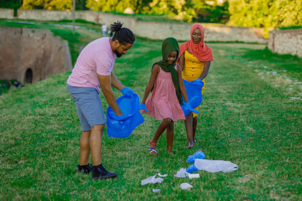 一个穆斯林家庭正在草地上捡垃圾。图片下载