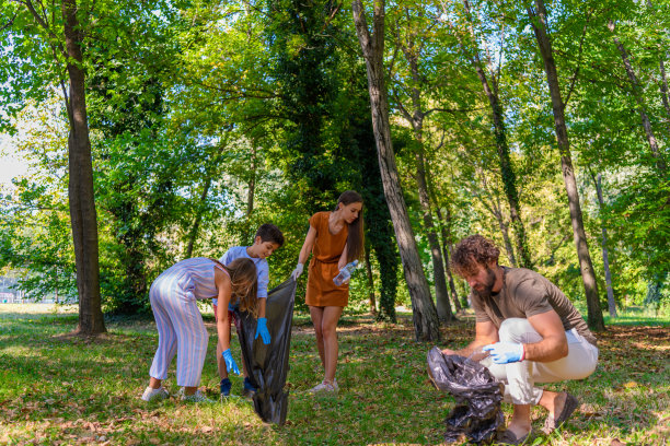 欢快的年轻家庭正在收集袋子里的垃圾。图片下载