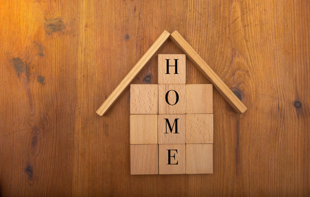 房子在木块的桌子上，上面写着家，买或租的概念图片下载