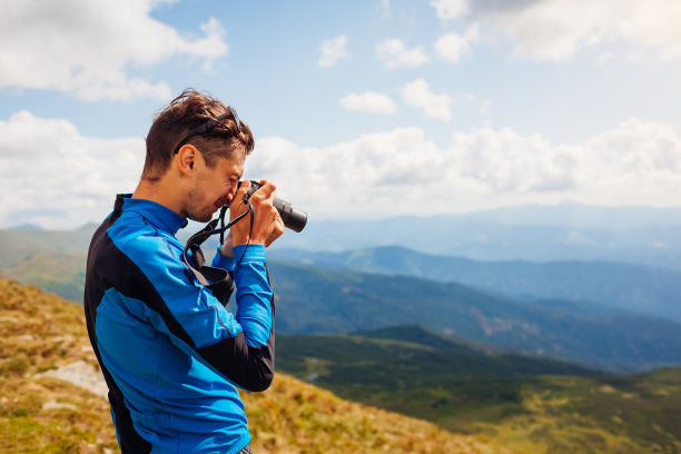 摄影师拍摄喀尔巴阡山脉景观。男人用相机拍照片和录像图片下载