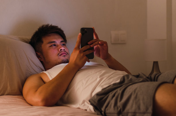 亚洲人在晚上使用智能手机图片下载