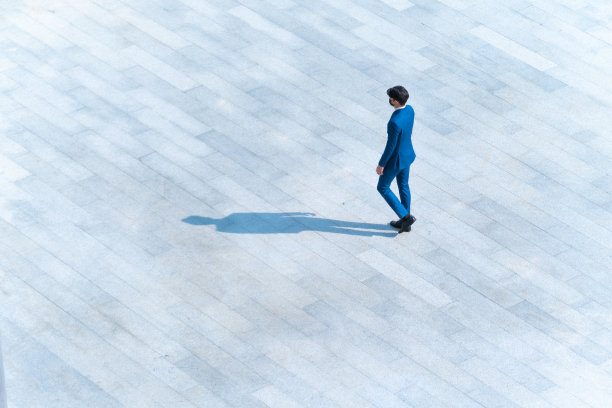 顶部鸟瞰商人们走在行人混凝土上，地面上有黑色的剪影，社会静物的概念。图片下载