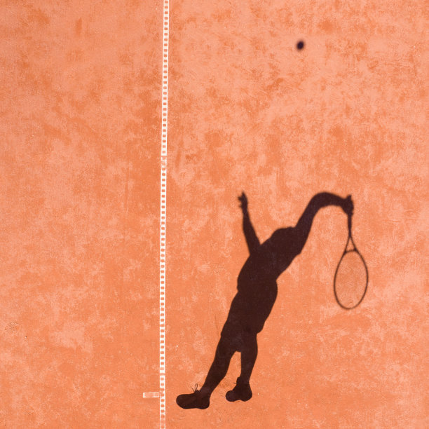 一个网球运动员的影子，他在发球时跳起反弹图片下载