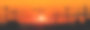 宽阔的工业景观全景上，许多建筑塔吊在火红和橘红色的夕阳映衬下。图片下载