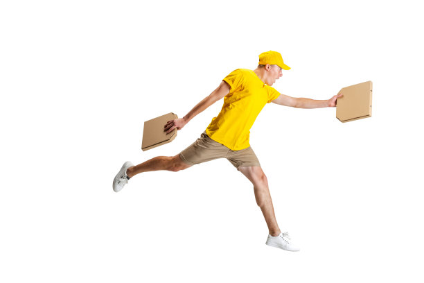 身着黄色制服的年轻快递员在白色背景下跑着送餐。方便、快捷、舒适、安全、服务的理念。图片下载