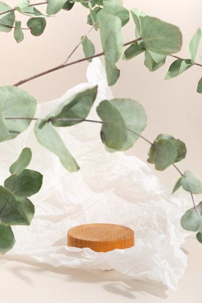 真实的照片。木台子上有桉树树枝的影子，光线硬朗。米色背景的化妆品在生态风格。模型。皱巴巴的羊皮纸图片下载