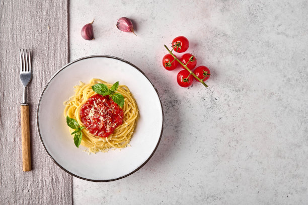 白色盘子上有番茄，帕尔马干酪，大蒜和罗勒的意大利面图片下载