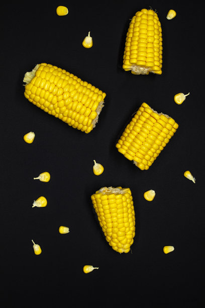 鲜黄色甜玉米穗轴上黑色的石板背景。对食物的概念。俯视图图片下载